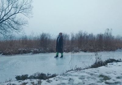 a man standing in the middle of a frozen pond