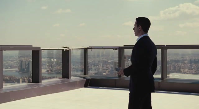 a man in a suit looking out over a city