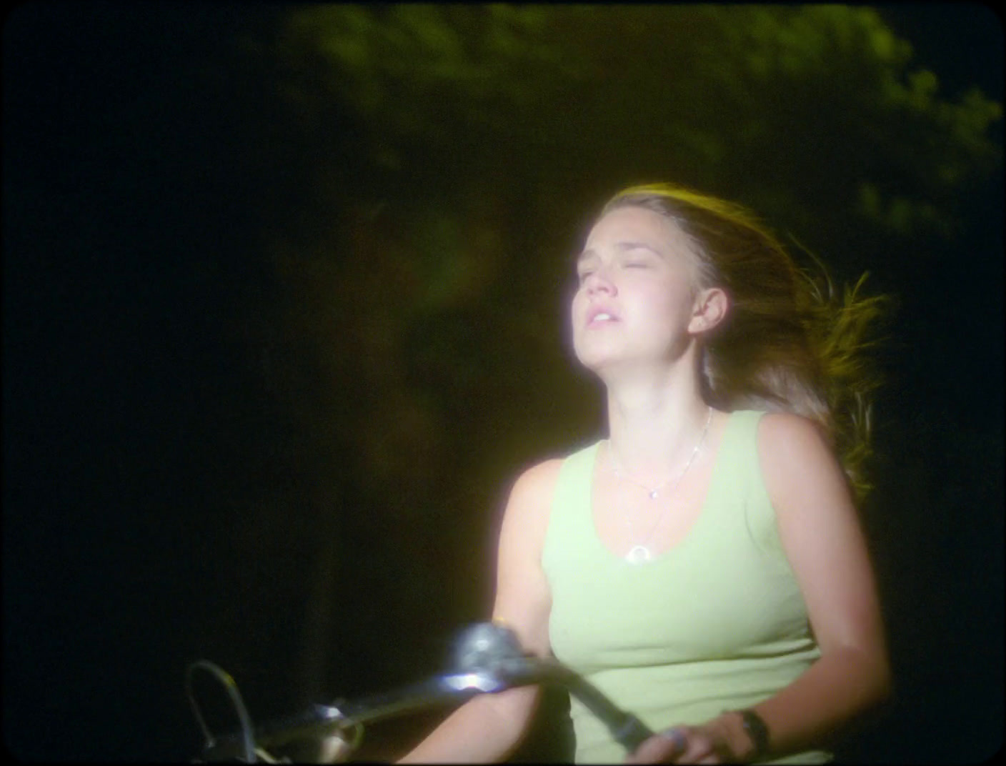 a young woman riding a motorcycle at night