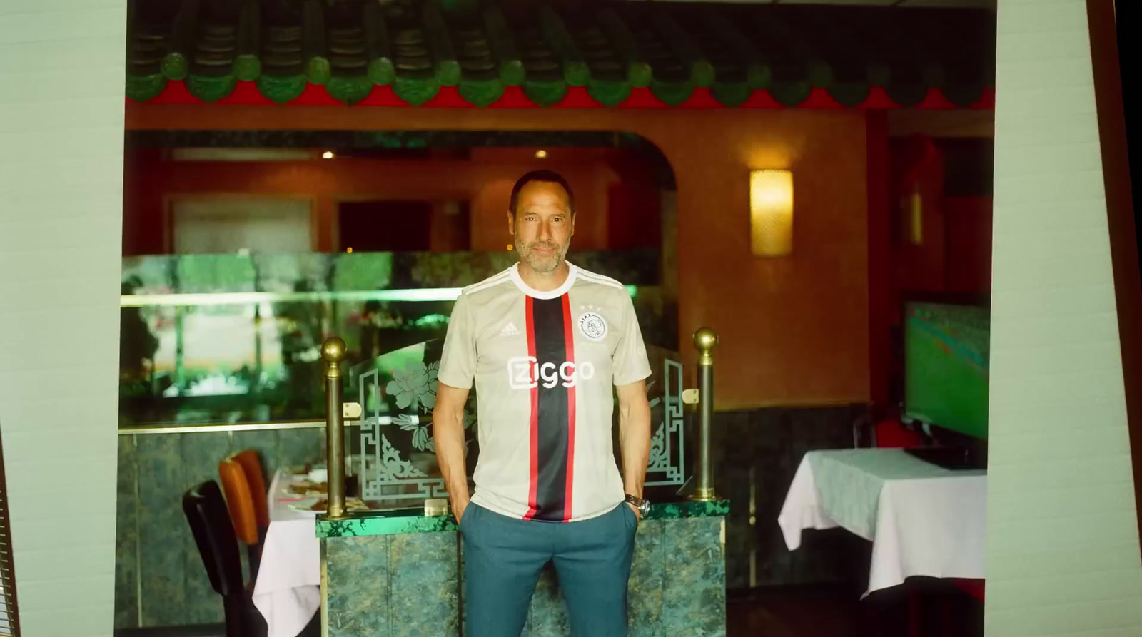 a man standing in front of a table in a restaurant