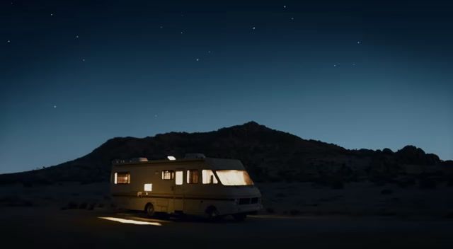 an rv parked in the middle of a desert at night