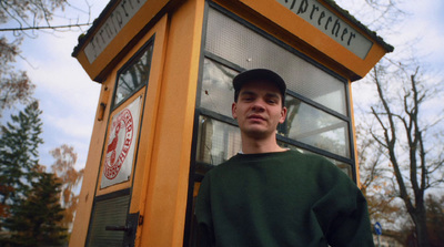 a man standing in front of a phone booth