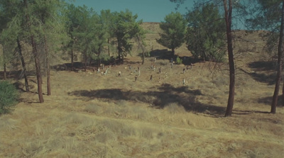 a group of people walking through a dry grass field