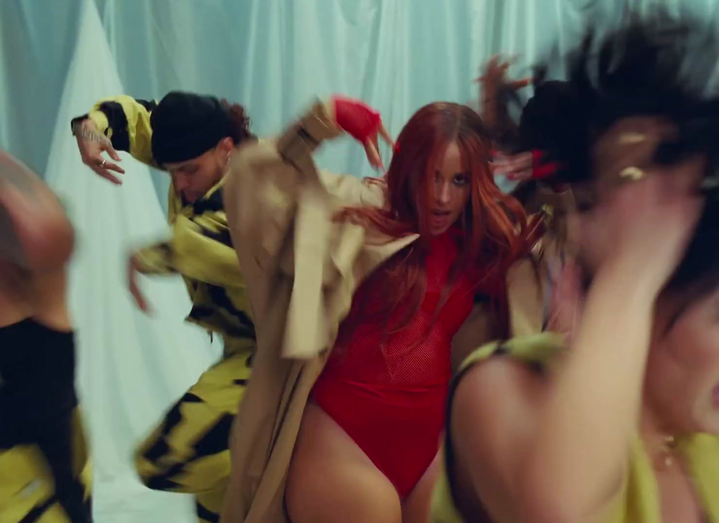 a woman in a red bodysuit is dancing