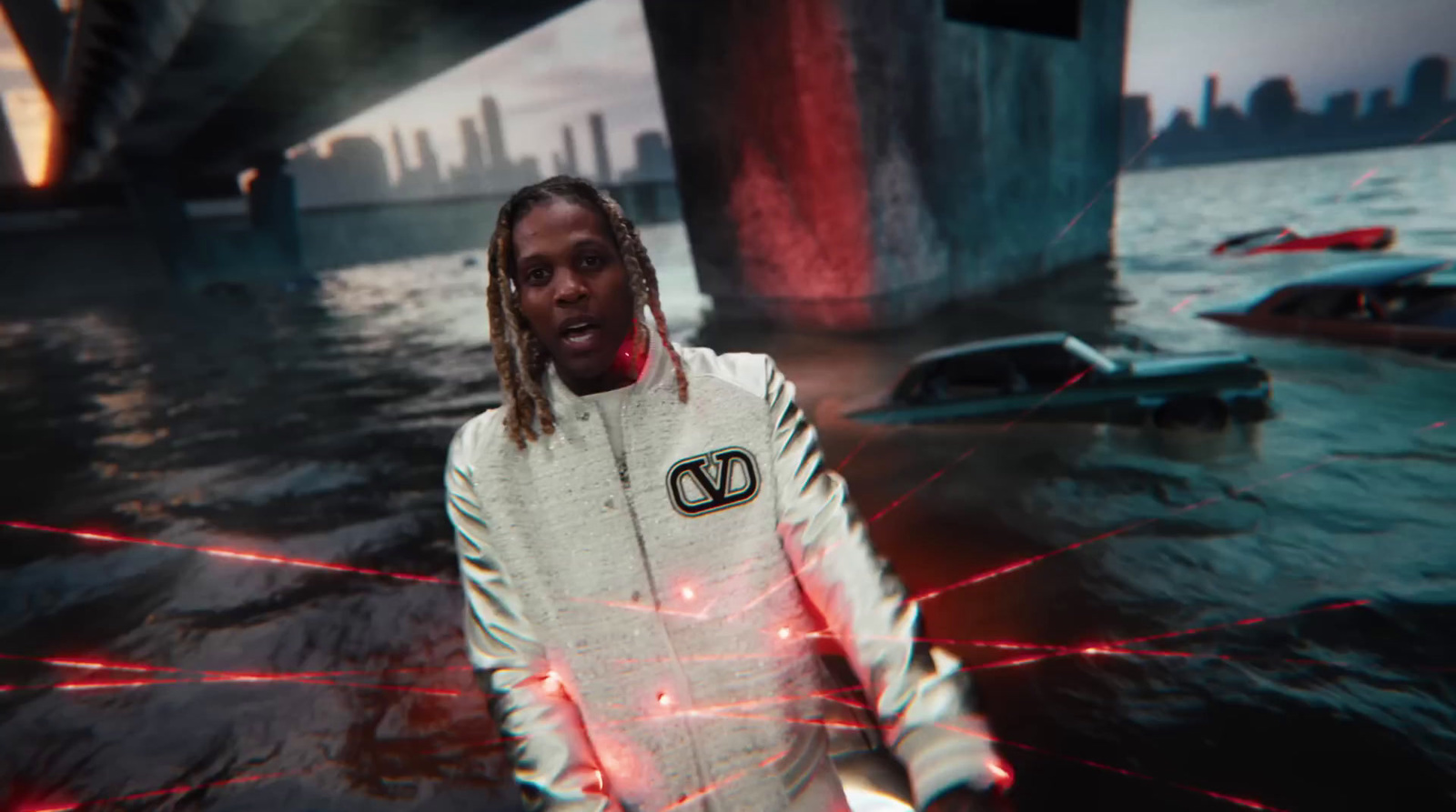 a man with dreadlocks standing in front of a body of water