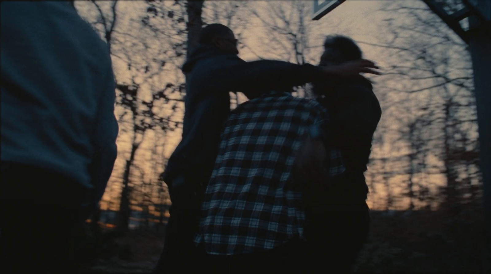 a group of people standing around each other in the woods