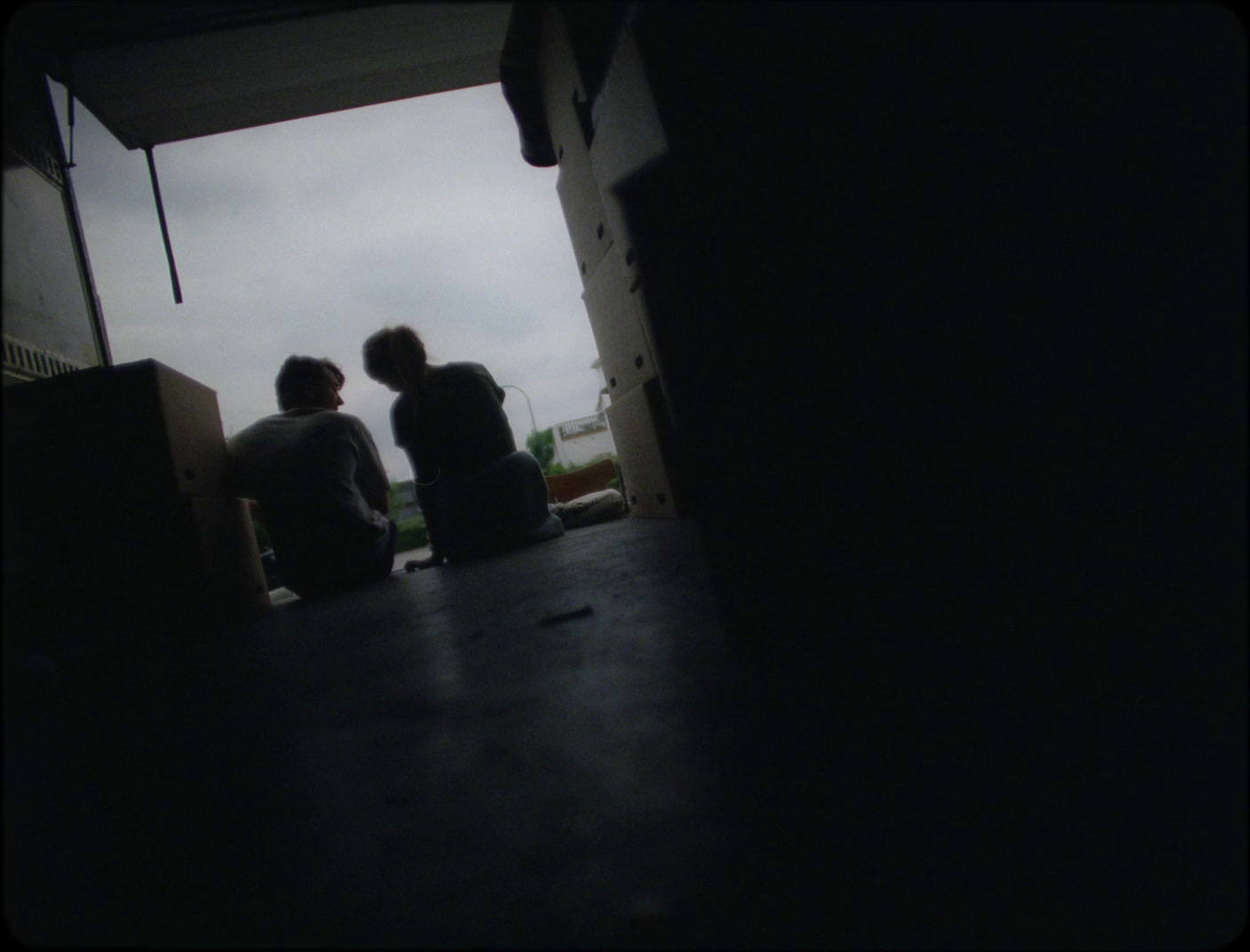 a couple of people sitting on top of a wooden table