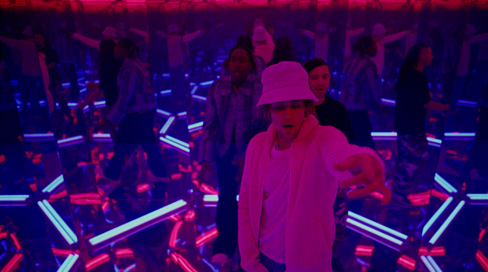 a man in a pink hat standing in a room full of people