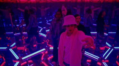 a man in a pink hat standing in a room full of people