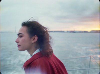 a woman standing on a boat looking out at the water