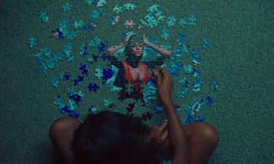 a woman sitting on the floor surrounded by puzzle pieces