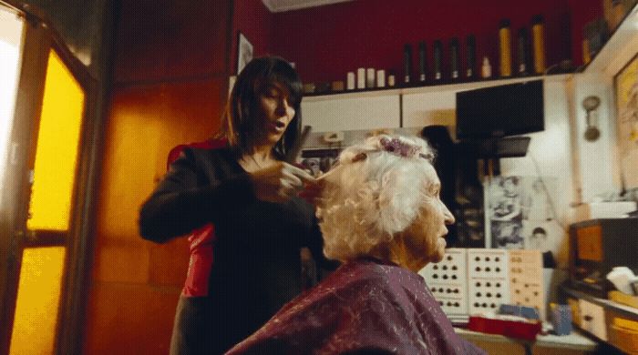 a woman getting her hair cut in a salon