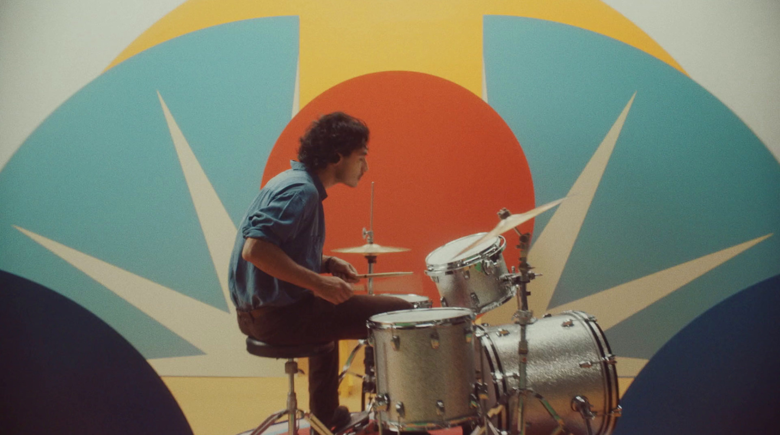 a man sitting on top of a drum set