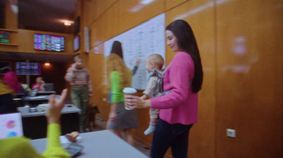 a woman in a pink jacket holding a baby