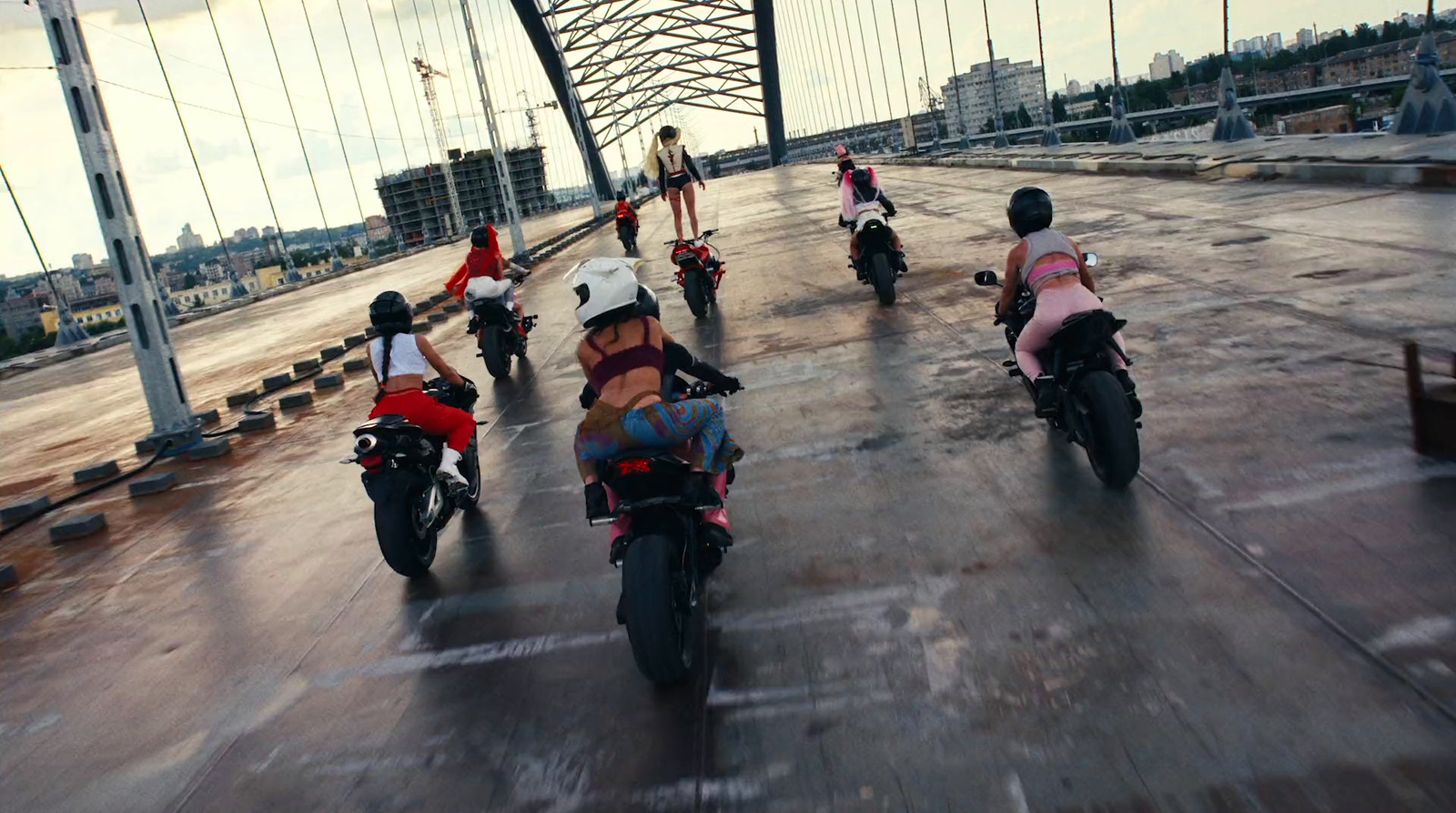 a group of people riding motorcycles across a bridge