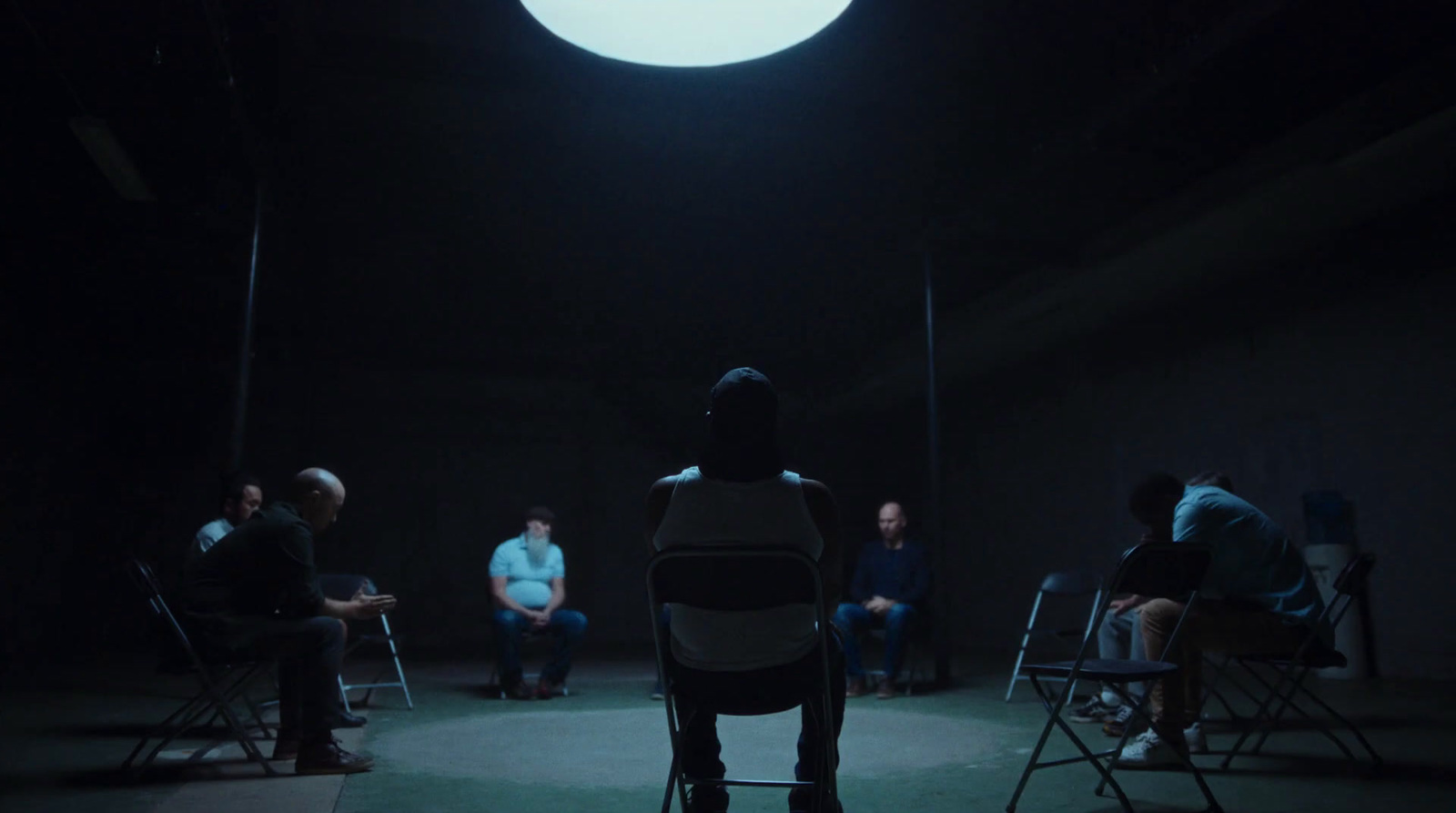 a group of people sitting in chairs in a dark room