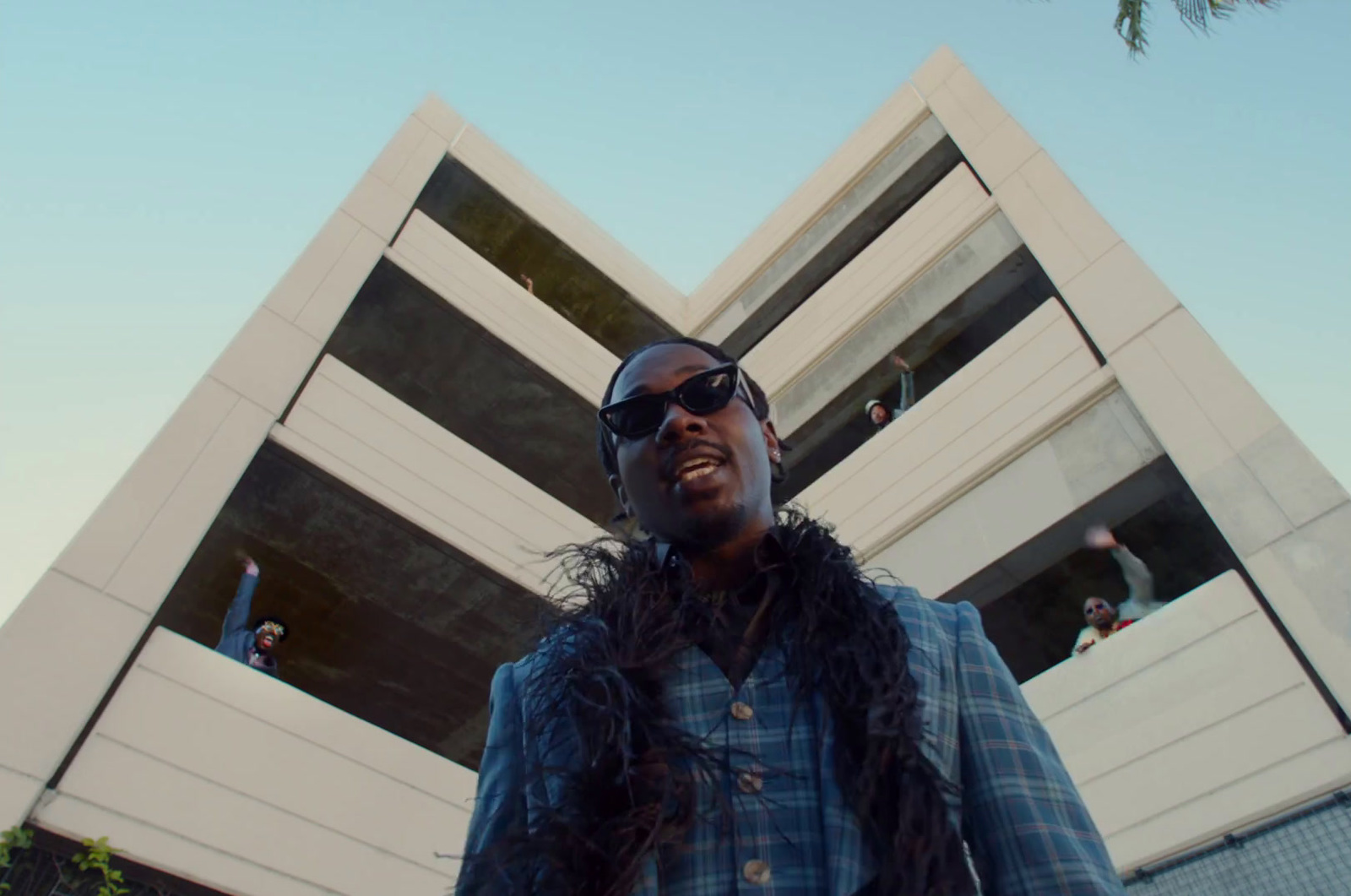 a man wearing sunglasses standing in front of a building