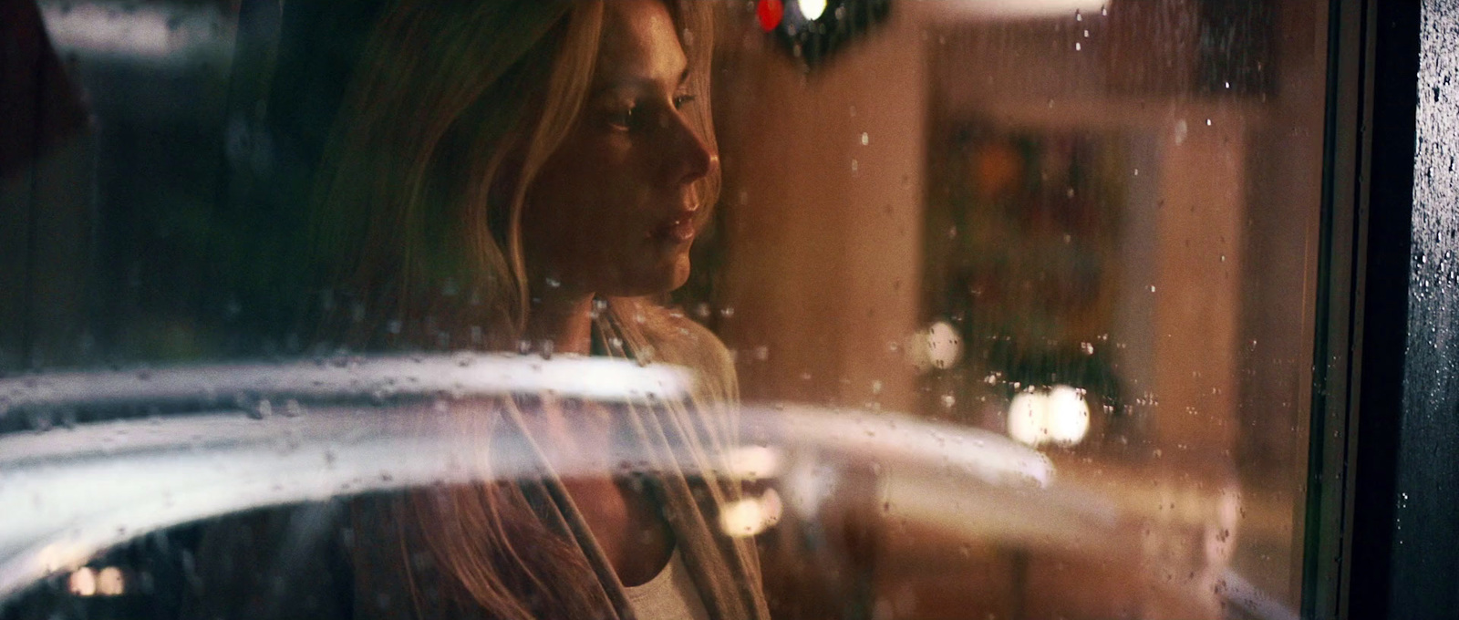 a woman looking out of a window at a christmas tree