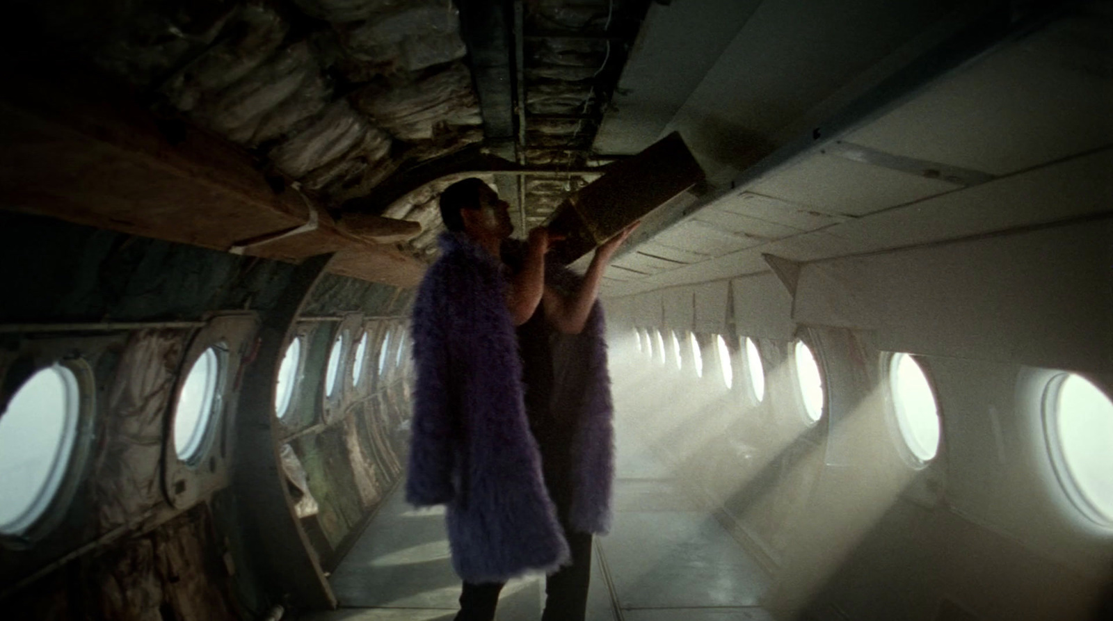 a woman standing in an airplane looking out the window