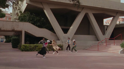 a group of people walking down a street next to a building