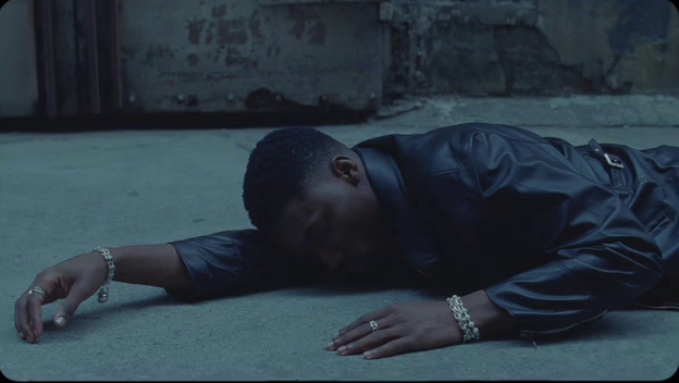 a man laying on the ground in a black jacket