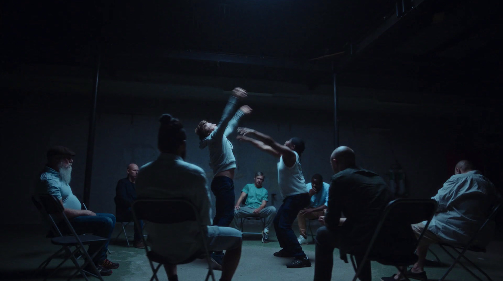 a group of people sitting in chairs in a dark room