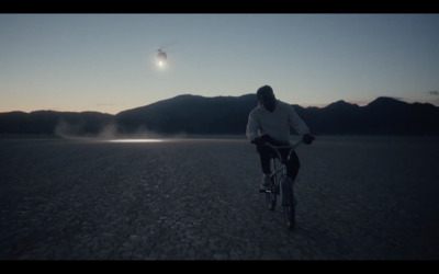 a man riding a bike in the middle of a desert