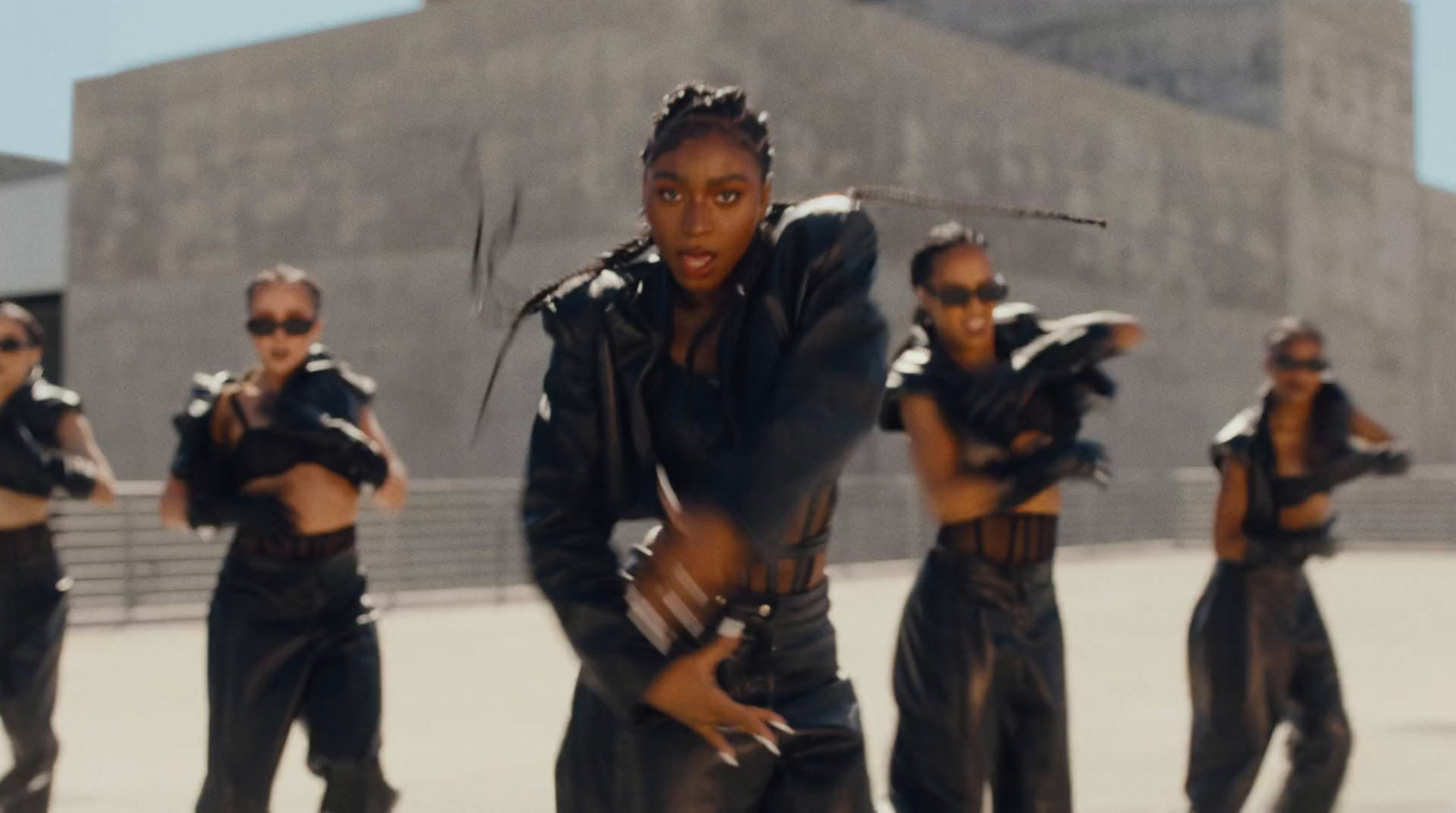 a group of women in black outfits are dancing