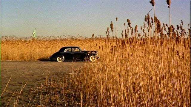 an old car is parked in a field