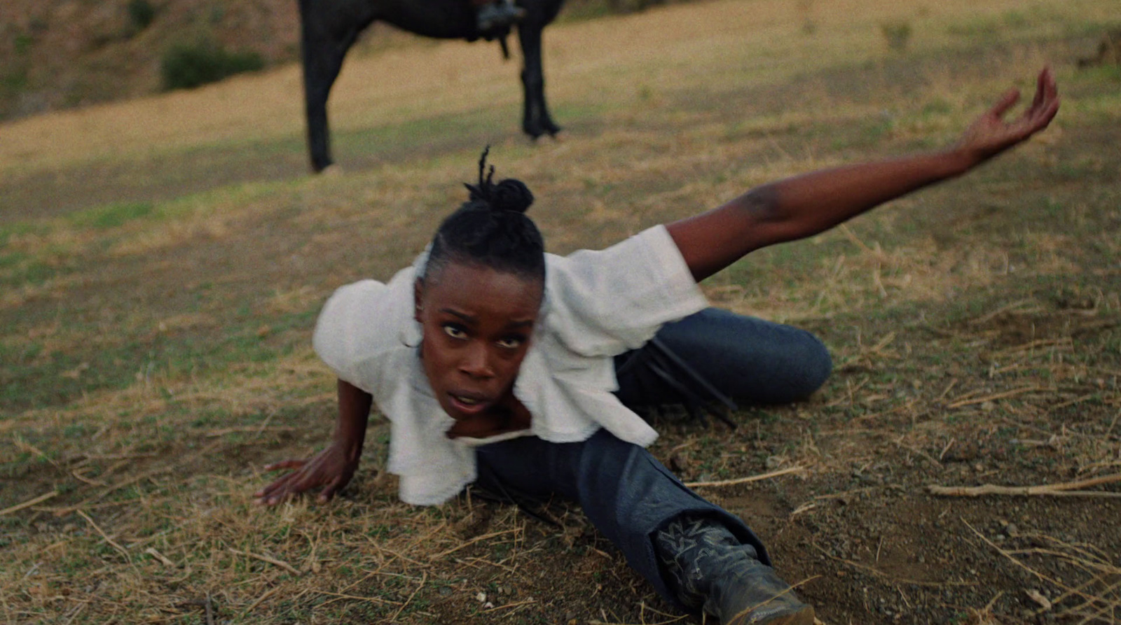 a woman laying on the ground next to a cow