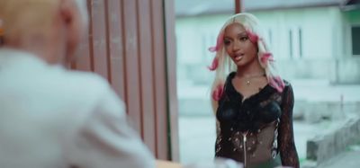 a woman with pink hair standing in front of a mirror