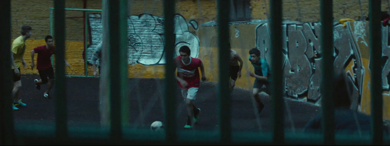 a group of people playing soccer in a fenced in area