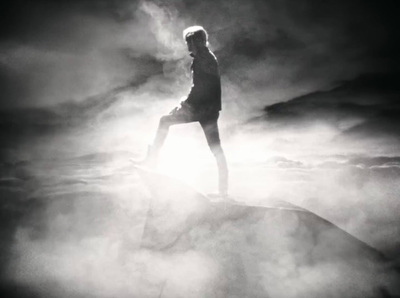 a man standing on top of a rock in the fog