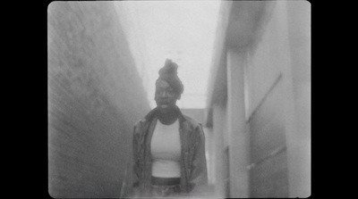 a black and white photo of a person walking down a hallway