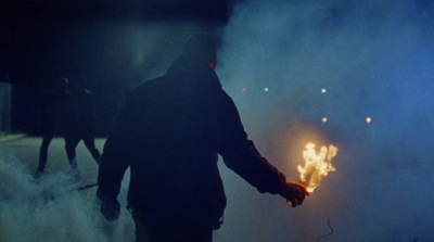 a man standing in front of a fire in the dark