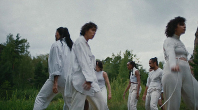 a group of women walking across a lush green field