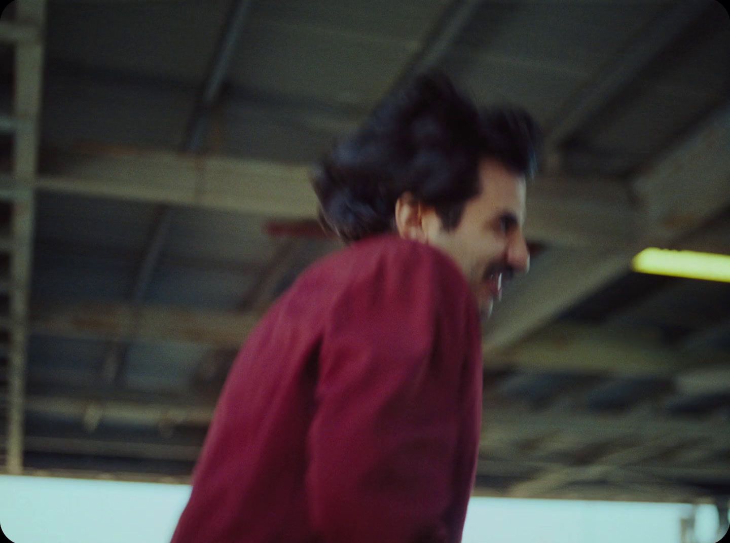 a man in a red shirt riding a skateboard