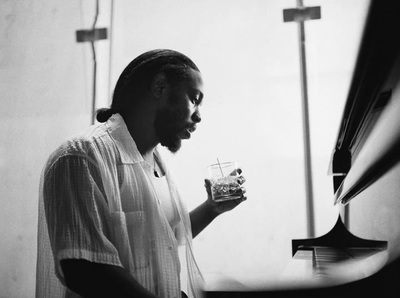 a black and white photo of a man holding a glass