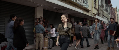 a woman walking down a street while talking on a cell phone