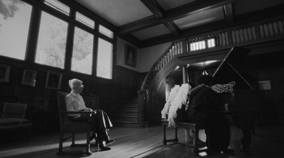 a man sitting in a chair next to a piano