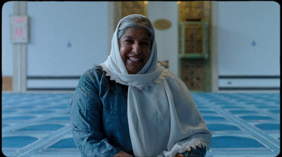 a woman in a headscarf smiles for the camera