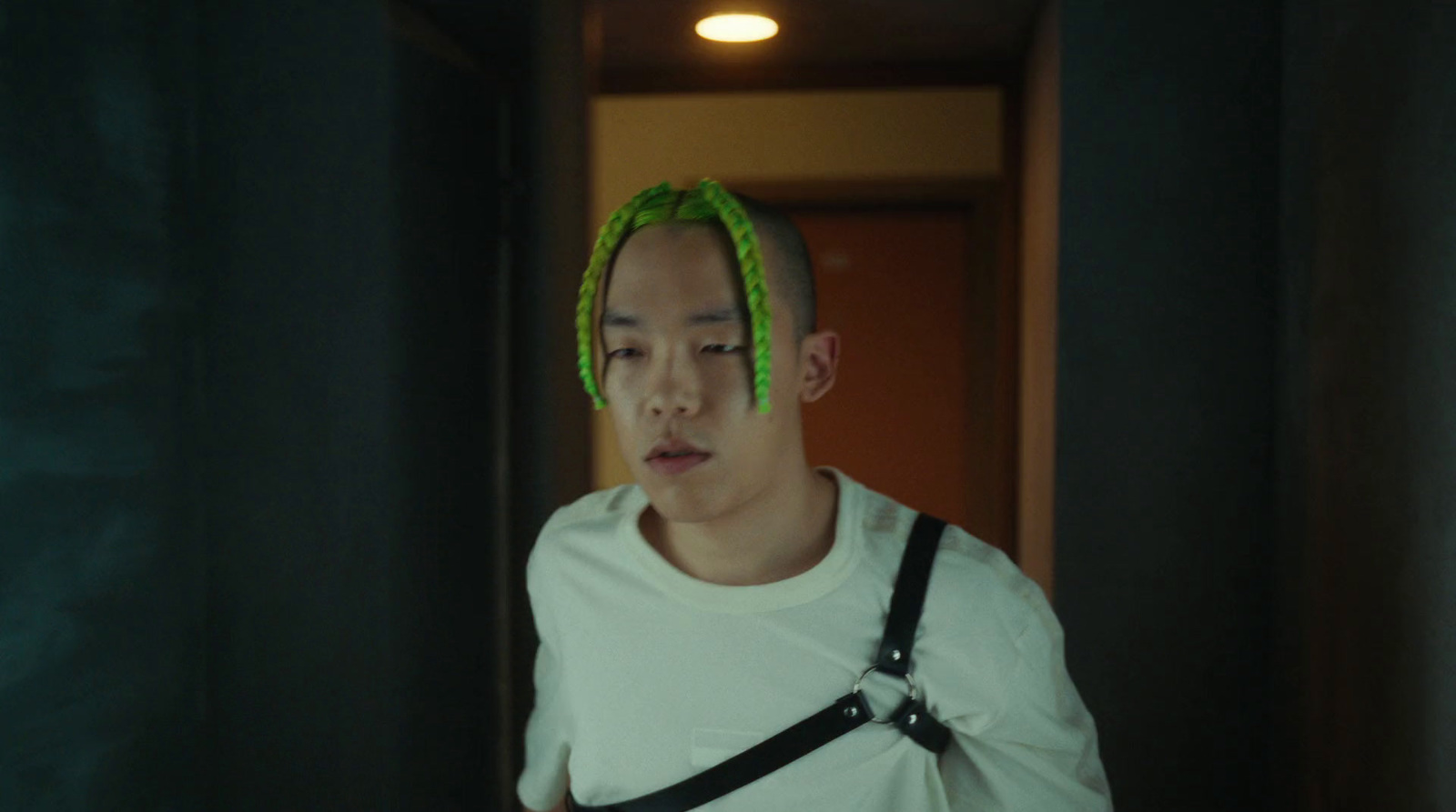 a man with green dreadlocks in a hallway