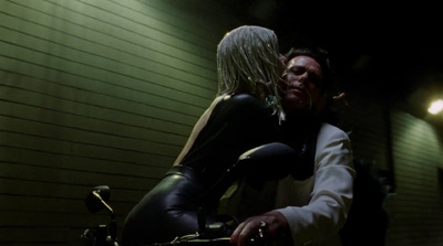 a man and a woman kissing on a motorcycle