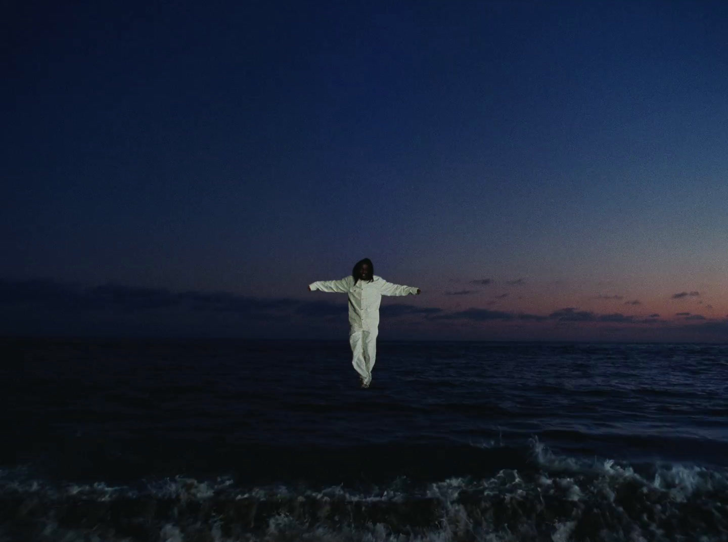 a person standing on a beach at night