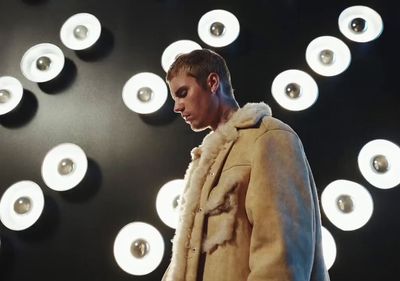 a man standing in front of a wall of lights