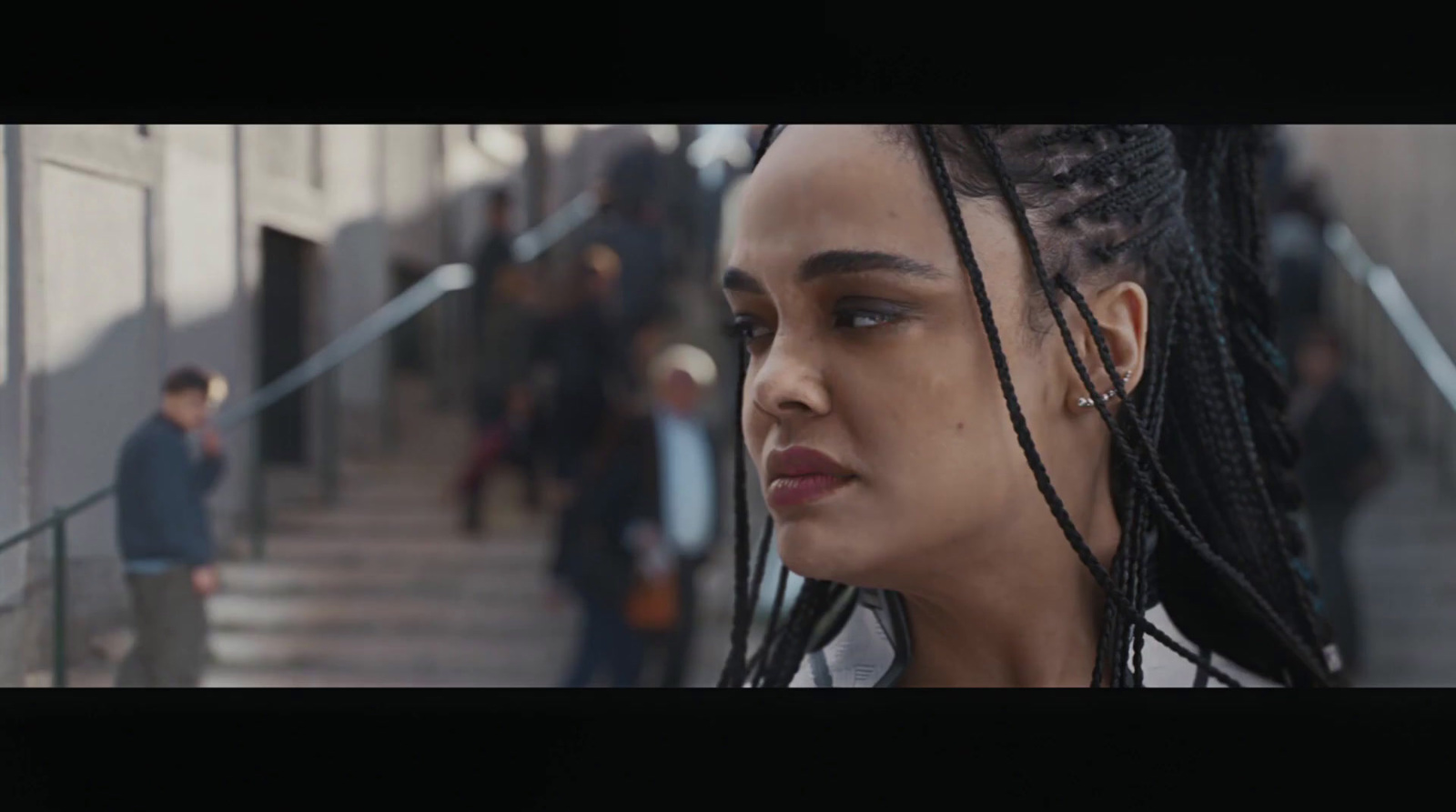 a woman with dreadlocks walking down a flight of stairs