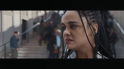 a woman with dreadlocks walking down a flight of stairs