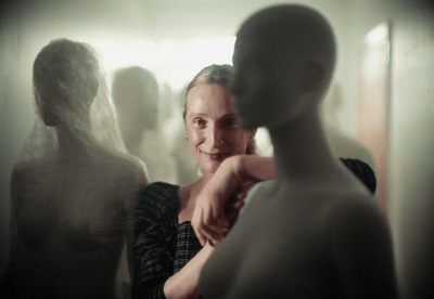 a woman standing in front of a white mannequin