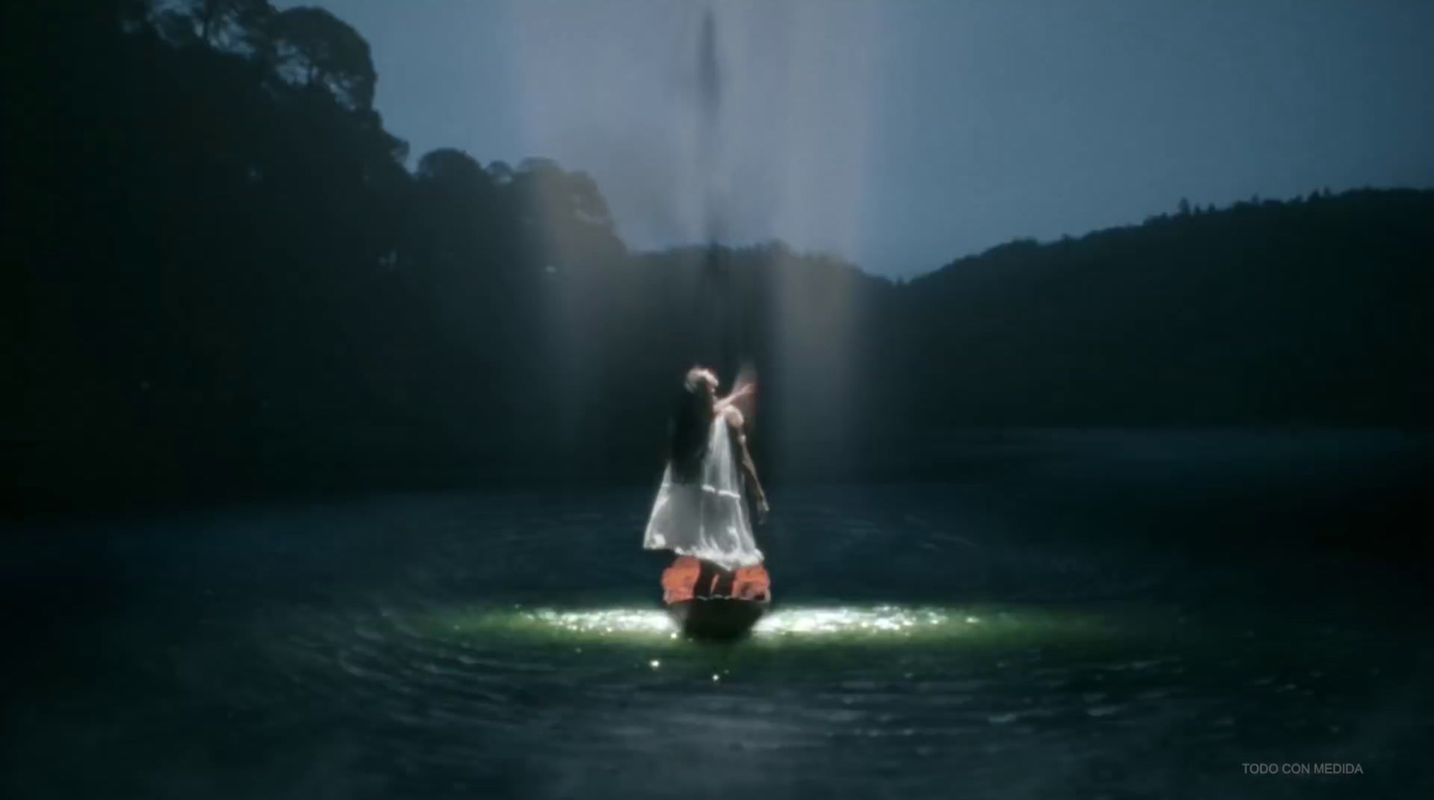 a woman in a white dress standing in the water