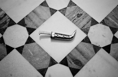 a razor blade laying on a tiled floor